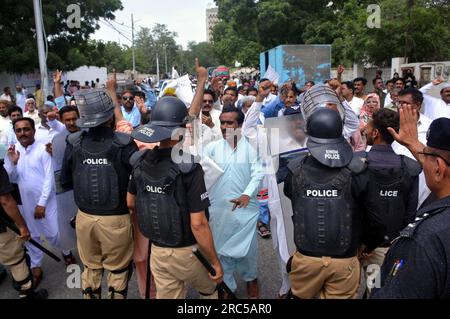 Hyderabad, Pakistan, 12. Juli 2023. Sicherheitsbeamte stellen den Baton-Angriff wieder her, benutzten Wasserkanonen und Verhaftungen, um Demonstranten abzuwehren, während sie sich während der Protestdemonstration der All Sindh Primary Teachers Association for Regularization am Mittwoch, den 12. Juli 2023 in Karatschi auf den Weg zum CM House bewegen. Stockfoto