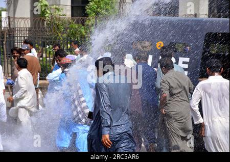 Hyderabad, Pakistan, 12. Juli 2023. Sicherheitsbeamte stellen den Baton-Angriff wieder her, benutzten Wasserkanonen und Verhaftungen, um Demonstranten abzuwehren, während sie sich während der Protestdemonstration der All Sindh Primary Teachers Association for Regularization am Mittwoch, den 12. Juli 2023 in Karatschi auf den Weg zum CM House bewegen. Stockfoto
