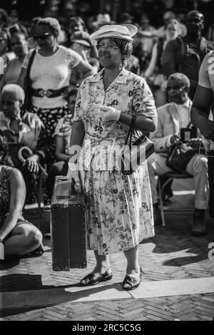 Ein Schwarzweißbild einer Frau, die sich am Windrush Day und seinem 75. Jahrestag als "Windrush Generation"-Migrantin verkleidet hat. Stockfoto
