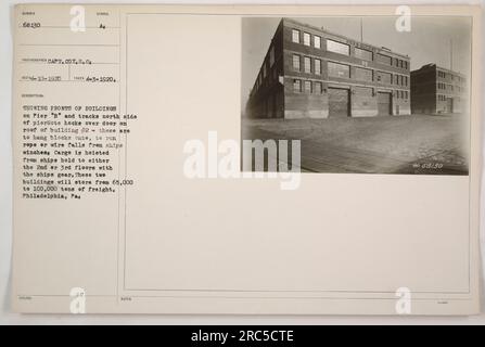 Gebäude auf Pier „B“ und Pfade auf der Nordseite des Piers. Über der Tür auf dem Dach von Gebäude Nr. 2 befinden sich Haltevorrichtungen, die zum Aufhängen von Blöcken verwendet werden, um Seile oder Drahteinbrüche von Schiffswinden zu verlegen. In diesen Gebäuden können zwischen 65.000 und 100.000 Tonnen Fracht gelagert werden. Das Hotel befindet sich in Philadelphia, PA. Foto aufgenommen am 3. April 1920. Symbol: RECI-10-1920. Fotograf: Captain Cox S. Co Beschreibung: Mit Fassaden von Gebäuden. Stockfoto