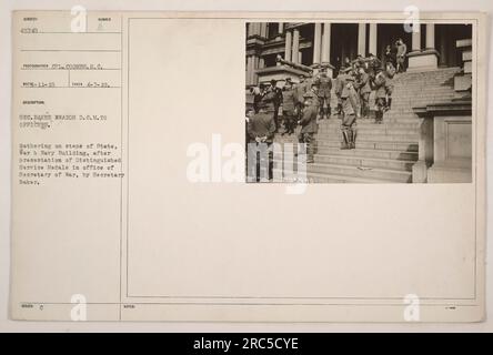 Minister Baker überreicht den Offizieren auf den Stufen des State, war & Navy Building ausgezeichnete Dienstmedaillen. Die Auszeichnungen wurden während einer Zeremonie im Büro des Kriegsministers verliehen. Das Foto wurde am 7. April 1919 von Corporal Coombs aufgenommen. Soldaten versammelten sich für die Veranstaltung. Stockfoto