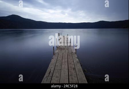 Die Atmosphäre vor der Dämmerung wird in einem traumhaften Langzeitfoto eines nebligen Sees festgehalten Stockfoto