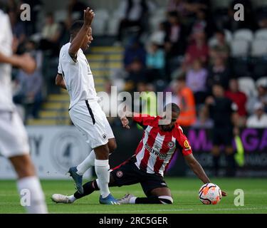 Angelo Balanta von Boreham Wood (links) und Rico Henry von Brentford kämpfen bei einem Freundschaftsspiel im LV BET Stadium Meadow Park, Borehamwood, um den Ball. Bilddatum: Mittwoch, 12. Juli 2023. Stockfoto