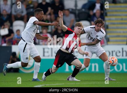 Angelo Balanta von Boreham Wood (links) und Cameron Coxe kämpfen mit Keane Lewis-Potter von Brentford bei einem Freundschaftsspiel im LV BET Stadium Meadow Park, Borehamwood. Bilddatum: Mittwoch, 12. Juli 2023. Stockfoto