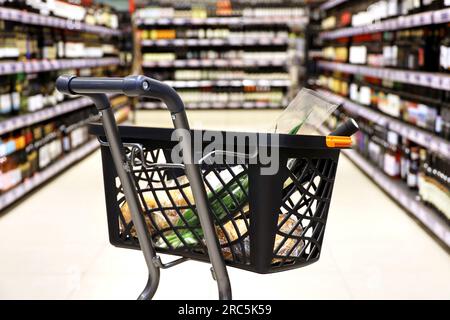 Einkaufswagen mit Essen in einem Supermarkt. Kunden während des Verkaufs Stockfoto