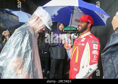 Der NASCAR-Stock-Car-Fahrer Bubba Wallace unterhält sich mit anderen Fahrern, während Regen den Start des NASCAR-Cup-Rennens verzögert. Die Grant Park 220 Series findet am 2. Juli 2023 in der Innenstadt von Chicago statt. Sintflutartige Regenfälle und Überschwemmungen verzögerten den Start des ersten Straßenrennen der NASCAR Cup-Serie. (Foto: Alexandra Buxbaum/Sipa USA) Guthaben: SIPA USA/Alamy Live News Stockfoto