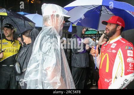 Der NASCAR-Stock-Car-Fahrer Bubba Wallace unterhält sich mit anderen Fahrern, während Regen den Start des NASCAR-Cup-Rennens verzögert. Die Grant Park 220 Series findet am 2. Juli 2023 in der Innenstadt von Chicago statt. Sintflutartige Regenfälle und Überschwemmungen verzögerten den Start des ersten Straßenrennen der NASCAR Cup-Serie. (Foto: Alexandra Buxbaum/Sipa USA) Guthaben: SIPA USA/Alamy Live News Stockfoto