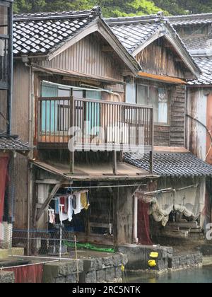 Malerisches Dorf Inine: Nahaufnahme der hölzernen Bootshäuser, Fayas, mit Balkonen im ersten Stock über den Fischernetzen im Bootsladen darunter. Stockfoto