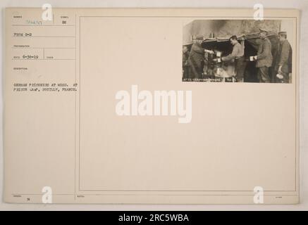 Deutsche Häftlinge essen in einem Gefangenenlager in Souilly, Frankreich. Das Foto wurde von einem G-2-Fotografen aufgenommen und am 30. Juni 1919 erhalten. Das Foto zeigt eine Gruppe deutscher Gefangener, die zusammen sitzen und essen. Stockfoto