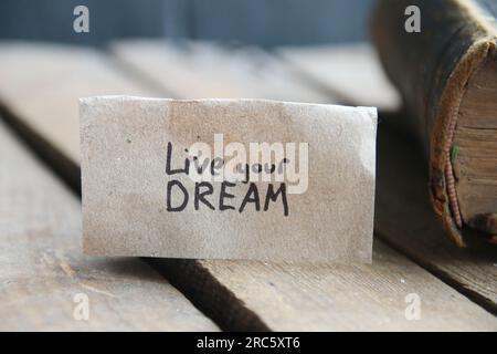 Lebe deine Traumkarte. Die Inschrift auf dem Schild. Vintage-Style. Motivierende Zitate. Stockfoto