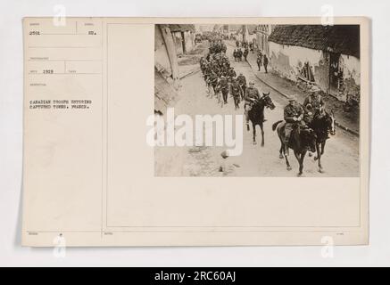 Kanadische Truppen marschieren durch die im Ersten Weltkrieg in Frankreich gefangenen Städte. Das Foto wurde 1919 vom Fotografen Red aufgenommen. Das Bild stellt das Symbol kanadischer Militäraktionen dar und zeigt die aufstrebenden kanadischen Soldaten auf feindlichem Gebiet. Das Foto zeigt die Beteiligung kanadischer Streitkräfte auf den Schlachtfeldern Europas. Stockfoto