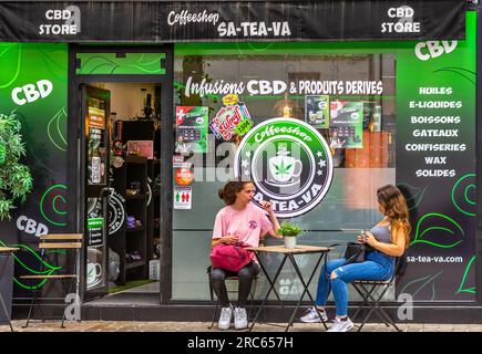 Zwei junge Frauen saßen vor dem CBD Legal Cafe im Stadtzentrum - Tours, Indre-et-Loire (37), Frankreich. Stockfoto