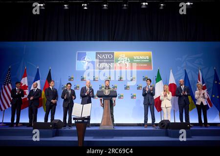 Vilnius, Litauen. 12. Juli 2023. Der ukrainische Präsident Volodymyr Zelenskyy, Center, hält während einer Veranstaltung mit G7 Staats- und Regierungschefs eine gemeinsame Unterstützungserklärung für die Ukraine während des NATO-Gipfels im litauischen Ausstellungs- und Kongresszentrum am 12. Juli 2023 in Vilnius, Litauen, vor. Von links: Britischer Premierminister Rishi Sunak, deutscher Kanzler Olaf Schotz, französischer Präsident Emmanuel Macron, japanischer Premierminister Fumio Kishida, USA Präsident Joe Biden, Ukrainischer Präsident Wolodymyr Zelenskyy, Kanadischer Premierminister Justin Trudeau, Italienischer Premierminister Giorgia Melo Stockfoto