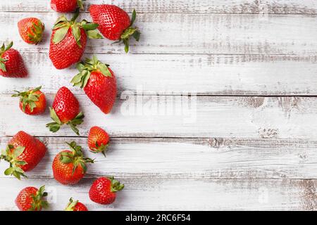 Beeren großer reifer, frischer biologischer Erdbeeren auf Holzhintergrund, Nahaufnahme, Draufsicht, mit Platz für Text. Stockfoto