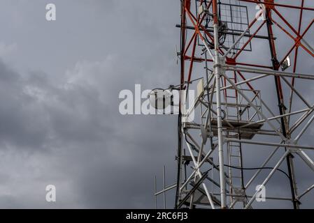 Ein Telekommunikationsturm mit Antennen und einer Servicetreppe Stockfoto