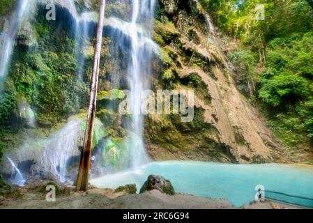 Oslob, Cebu,|Philippinen-Januar 25 2023: Touristen schwimmen im frischen, klaren Bergwasser und stehen unter der Kraft der kühlen, fallenden Ströme Stockfoto