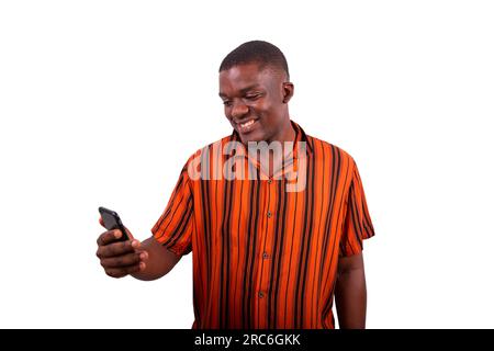 Ein junger Afrikaner benutzt sein Smartphone und lächelt, Modell isoliert auf weißem Hintergrund Stockfoto