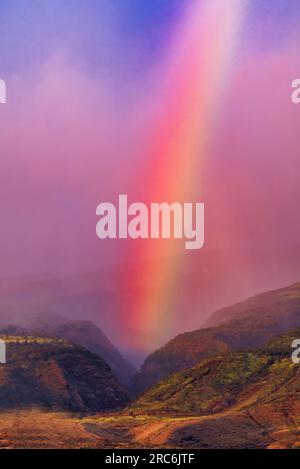Atemberaubende Landschaft eines abendlichen Regenbogens, eingebettet in ein maui-Tal. Stockfoto