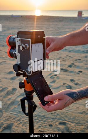 Ein Fotograf lädt 120-Filme in eine klassische Spiegelreflexkamera mit zwei Objektiven. Stockfoto