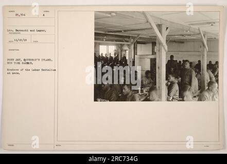 Mitglieder des Arbeitsbataillons genießen hier ihre Mahlzeit in Fort Jay, das sich auf Governor's Island im Hafen von New York befindet. Das Foto wurde von LTS aufgenommen. Barsanti und Layer am 18. November 1918. Dieses Bild zeigt die täglichen Aktivitäten des amerikanischen Militärpersonals während des Ersten Weltkriegs Stockfoto