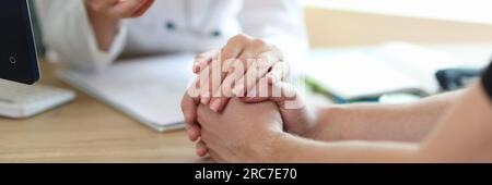 Weibliche Ärztin in weißer medizinischer Uniform, die männlichen Patienten im Krankenhaus konsultiert. Stockfoto