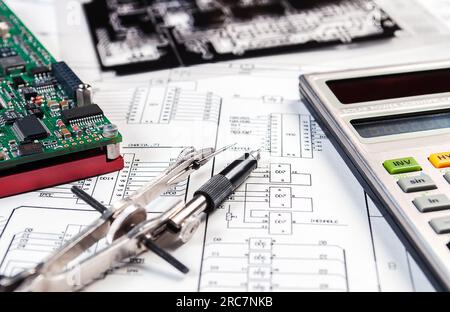 Elektronikkarte, Rechner, Pinzette und Fotomasken auf dem Hintergrund des Schaltplans. Konzept für Entwicklung und Design von elektronischen Entw Stockfoto