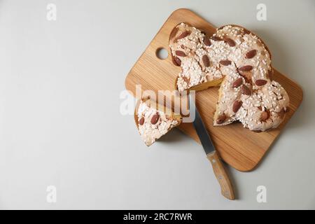 Gehen Sie an Bord mit einem köstlichen italienischen Ostertaubenkuchen (traditionell Colomba di Pasqua) auf einem hellgrauen Tisch, Draufsicht. Platz für Text Stockfoto