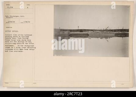 Die Abbildung zeigt eine allgemeine Ansicht des Schotts an der Army Supply Base in Port Newark. Im Hintergrund befinden sich große offene Schuppen, die zur Lagerung von Heu, technischen Materialien und Motoranlagen genutzt wurden. Im Vordergrund lädt ein Dampfkran Kaiserlöcher aus Übersee ab. Stockfoto