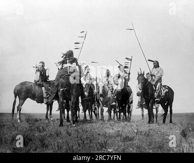 Montana 1908. Eine Edward S. Curtis Fotogravur von Atsina-Kriegern auf dem Pferderücken. Stockfoto