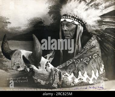 Montana: 1928. Foto von Cree Chief Mo-See-Ma-Mos, Young Boy, mit einem Büffelschädel. Er war der westliche Künstler Charlie Russells guter Freund und Lieblingsmodell. Stockfoto