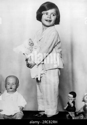 Rom, Italien: Juni 1930 die kleine Baronin Anna Soragno hält eine Puppe, die ihr von der italienischen Kronprinzessin überreicht wurde. Links ist eine Puppe von der Kronprinzessin von Belgien, ganz rechts eine von der Kronprinzessin von Norwegen, und die Puppe in der Mitte ist ein Geschenk von Prinzessin Ingrid von Schweden. Stockfoto