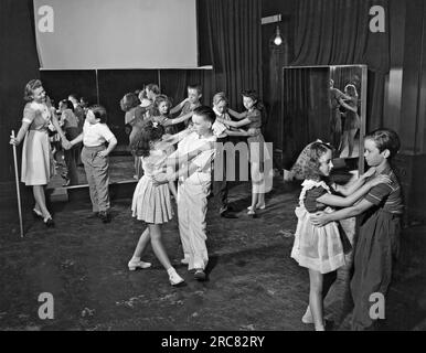 Hollywood, Kalifornien: ca. 1938. Junge Schauspieler in den Metro-Goldwyn-Mayer Studios müssen noch zur Schule gehen, und die Schule findet auf dem Studio-Parkplatz statt. Hier lernen die Schüler Volkstanz von der Lehrerin Jeanette Bates. Stockfoto