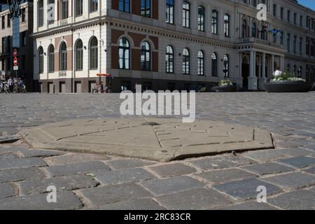 Stein auf dem Rathausplatz in der Stadt Riga in Lettland markiert den Ort, an dem der erste öffentliche Weihnachtsbaum im Jahr 1510 stehen soll Stockfoto