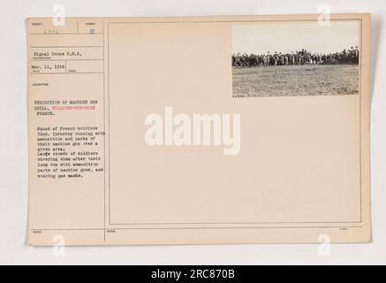 Französische Soldaten der 32. Infanterie, die am 11. März 1918 auf einer Maschinengewehrausstellung in Villiers-sur-Suze, Frankreich, mit Munition und Teilen ihres Maschinengewehrs unterwegs waren. Die Soldaten tragen Gasmasken und werden nach ihrem Lauf von einer großen Menge anderer Soldaten angefeuert. Stockfoto