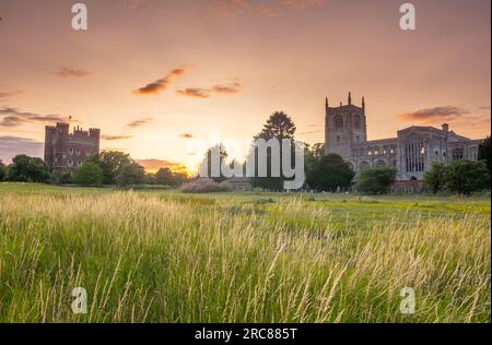 12. Juli 2023 Wetter in Großbritannien. Tattersall Castle, Lincolnshire, England. Die Abendsonne geht hinter dem beeindruckenden Tattersall Castle in Lincolnshire unter. Ebenfalls abgebildet ist die Holy Trinity Collegiate Church Info von der Website des National Trust - Tattershall Castle mit seinen riesigen gotischen Kaminen und kirchlichen Fenstern wurde entworfen, um Sie zu beeindrucken. Erbaut von Lord Ralph Cromwell, Schatzmeister von England, wurde es entworfen, um seinen Reichtum, seine Position und seine Macht zu zeigen. Der große Turm ist eines der frühesten und schönsten noch erhaltenen Beispiele für englisches mittelalterliches Mauerwerk A. Stockfoto