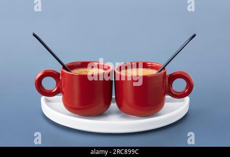 Zwei kleine süße rote Tassen gefüllt mit Espresso Stockfoto