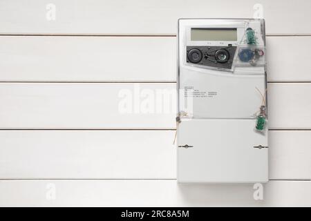 Stromzähler an weißer Holzwand, Platz für Text Stockfoto