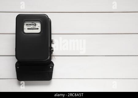Stromzähler an weißer Holzwand, Platz für Text Stockfoto