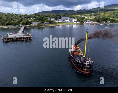 Jura, Vereinigtes Königreich. 13. Juli 2023: Das Puffer Dampfschiff, Vic 32, verlässt den Hafen in Craighouse auf der Insel Jura. Das Boot wurde Anfang 2023 umgebaut, damit es vollständig mit Biokraftstoffen betrieben werden kann, und ist das erste Kulturschiff in Großbritannien, das diesen Wechsel vollzogen hat. Kredit: Rich Dyson/Alamy Live News Stockfoto