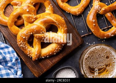 Frisch gebackene hausgemachte Brezeln und Bier vom Fass. Flach liegend Stockfoto