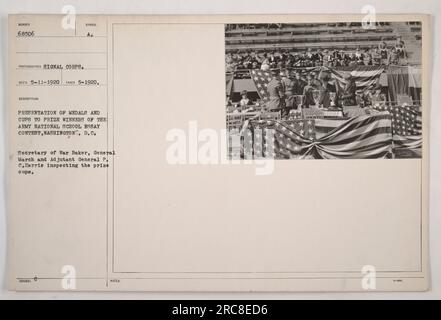 Das Bild zeigt die Präsentation von Pokalen und Medaillen an die Gewinner des Army National School Essay Contest in Washington, D.C. Kriegsminister Baker, General P.C. March und Adjutant General P.C. Harris kann gesehen werden, wie er die Preisbecher inspiziert. Das Foto wurde im Mai 1920 aufgenommen. Stockfoto