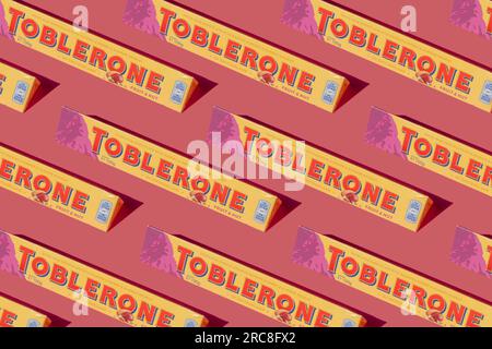 Tobleronmuster. Schweizer Schokolade mit aufgebrühtem Mandelnougat. Neues Berglogo auf pinkfarbenem Hintergrund. Süßigkeiten sind ein klassisches Souvenir der Schweiz, Mondelez. Kiew, Ukraine - 10. Juli 2023 Stockfoto