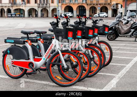 Padua, Italien - 4. April 2022: Ridemovi-Leihfahrräder in einer Straße in Padua, Italien. Der Service wird von der chinesischen Firma Mobike bereitgestellt. Stockfoto