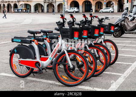 Padua, Italien - 4. April 2022: Ridemovi-Leihfahrräder in einer Straße in Padua, Italien. Der Service wird von der chinesischen Firma Mobike bereitgestellt. Stockfoto