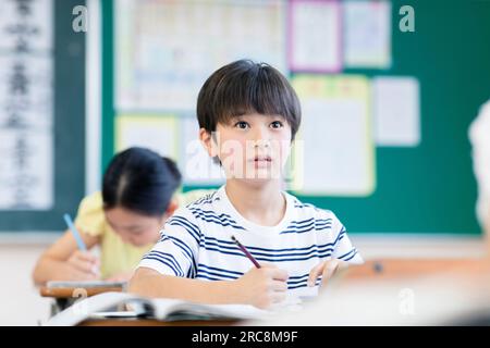 Eine Grundschülerin, die im Unterricht studiert Stockfoto