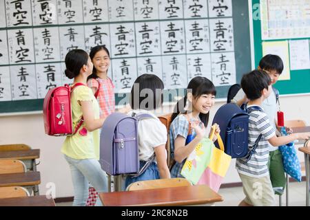 Die Schüler der Grundschule nehmen ihre Plätze ein, nachdem sie zur Schule gegangen sind Stockfoto