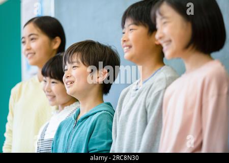 Grundschulkinder singen vor der Tafel Stockfoto