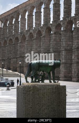 Antikes Rom, Blick auf eine Statue in Segovia von Romulus und Remus, die eine Wölfin saugt, mit dem riesigen römischen Aquädukt aus dem 1. Jahrhundert im Hintergrund, Spanien Stockfoto