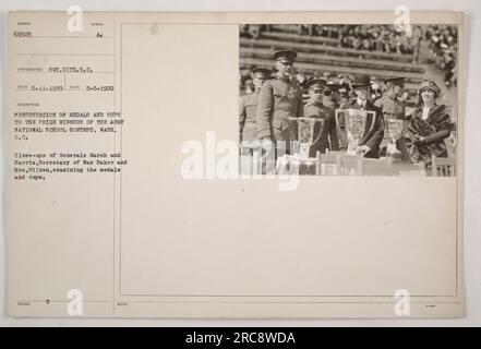 Das Bild zeigt die Präsentation von Medaillen und Pokalen an die Gewinner des Army National School Essay Contest in Washington, D.C. General March, General Harris, Kriegsministerin Baker und Mrs. Milliken können gesehen werden, wie sie die Pokale und Medaillen untersuchen. Das Foto wurde am 5. Mai 1920 vom Fotografen Hitz.S.C. aufgenommen Stockfoto