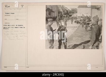 Soldaten versammeln sich während des Ersten Weltkriegs in einer kleinen Stadt in Frankreich. Auf dem Foto ist ein Horgler zu sehen, der den Ruf bläst, um die Männer zu alarmieren. Dieses Bild ist eines von vielen, die das Signal Corps als Teil ihrer Dokumentation über amerikanische Militäraktionen in Frankreich aufgenommen hat. Stockfoto